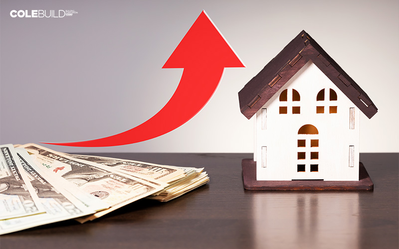 small house model beside a pile of cash